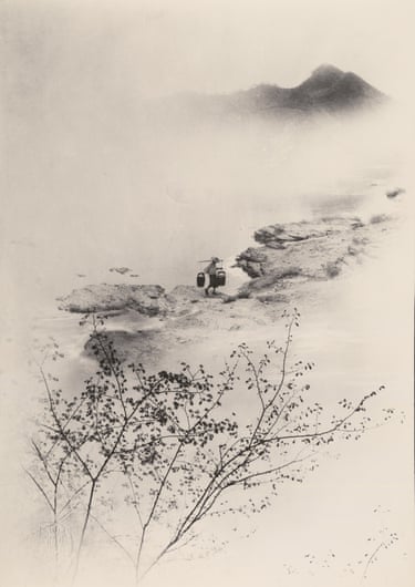 A figure carries baskets on a pole along a misty riverbank, mountains fading into fog