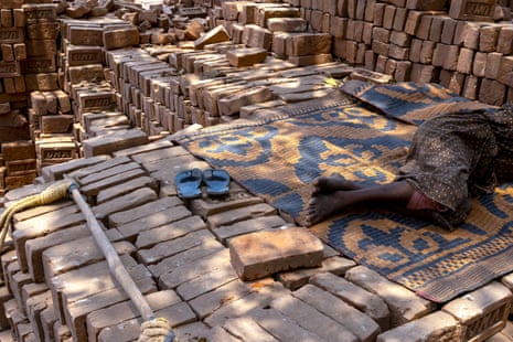 A pair of legs can be seen as the worker lies on a mat.