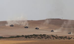 Turkish tanks and members of the Free Syrian Army pass the Syrian border.