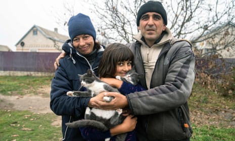 Viktor Galak 44, poses with his wife Svitlana, 43, and their 10-year-old daughter Anna in the liberated village of Pravdyne, Kherson region, on November 12, 2022, amid the Russian invasion of Ukraine.