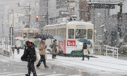 People cross a street in the snow in Toyama, Japan