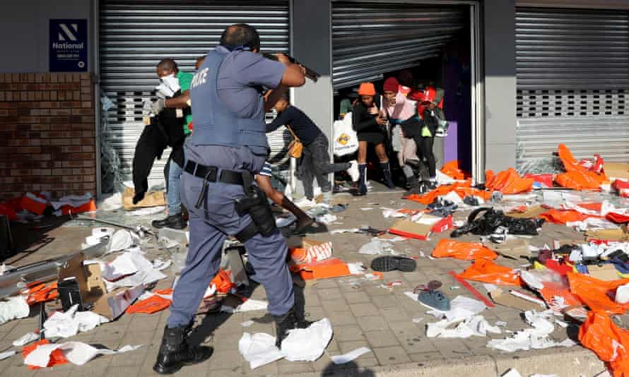 A member of the South African Police Forces tries to control looting during protests in Durban, South Africa, 12 July 2021.
