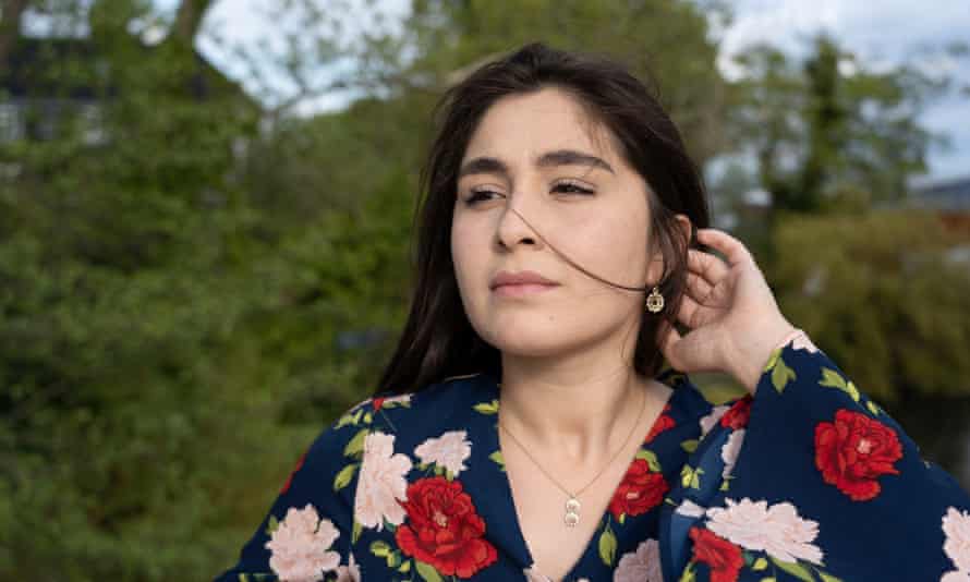 a young woman with long hair and a floral shirt 