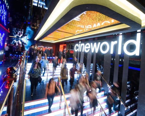 Customers descend illuminated steps under a Cineworld logo in a neon cinema atrium