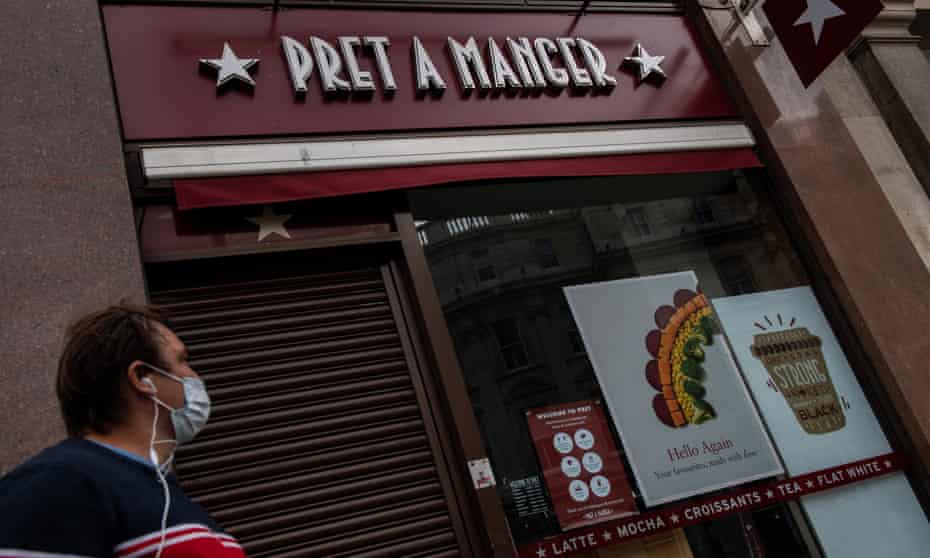 A man wearing a face mask walks past a closed Pret a Manger restaurant