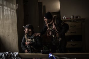Members of the Iraqi special forces look out for Islamic State militants from a house in the district of al-Barid