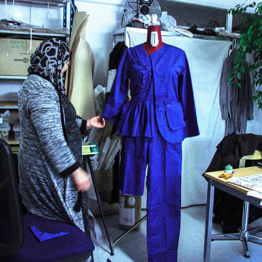 An employee in About A Worker’s studio uses material from an old garment.