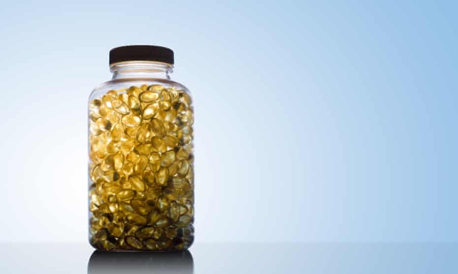 Amber glow through a bottle full of fish oil capsules