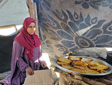 Esraa Abu Taiba, 26, in a makeshift tent wears a fuchsia hijab.