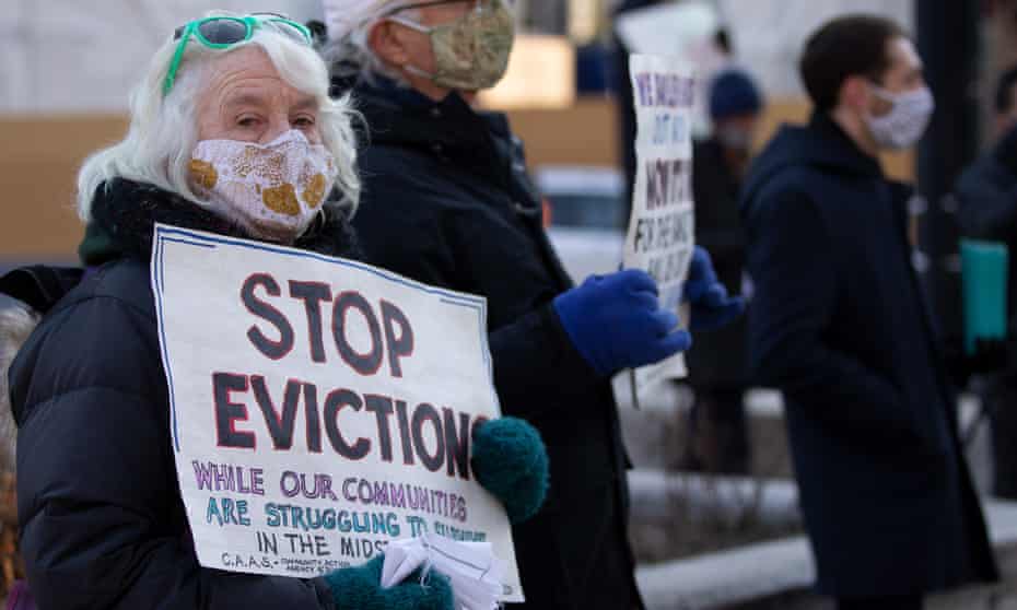Activists hold signs calling for stopping evictions in Boston.