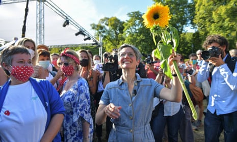 Sandrine Rousseau holding a sunflower