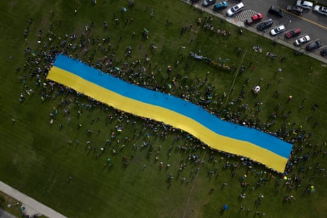 This aerial view shows protesters holding a giant Ukrainian flag in Anchorage, Alaska, on August 15, 2025 during a US-Russia summit at nearby Joint Base Elmendorf-Richardson. Donald Trump and Vladimir Putin made no apparent breakthrough on Ukraine in a high-stakes summit, pointing to areas of agreement and rekindling a friendship but offering no news on a ceasefire.