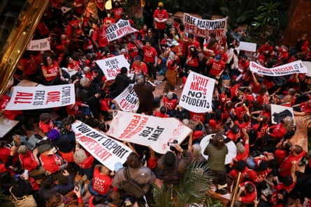 people wear red t-shirts and hold signs inside a building