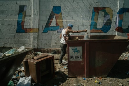 A man examine the contents of a bin in La Dolorita.