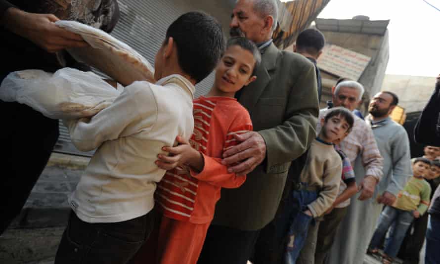 Syrians wait in line to buy bread in October 2012.