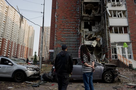 Bystanders look at a damaged residential building following drones strike on Ukraine's capital Kyiv.