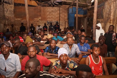 a group of people watching a movie in a wooden room