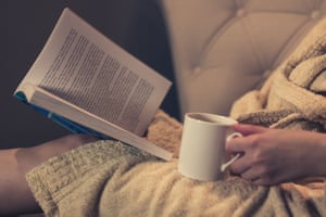 Woman reading a book on a cosy couch