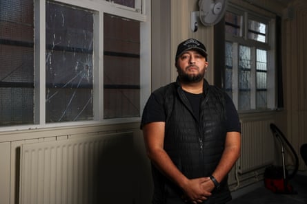 Khalid stands alongside some smashed/damaged windows