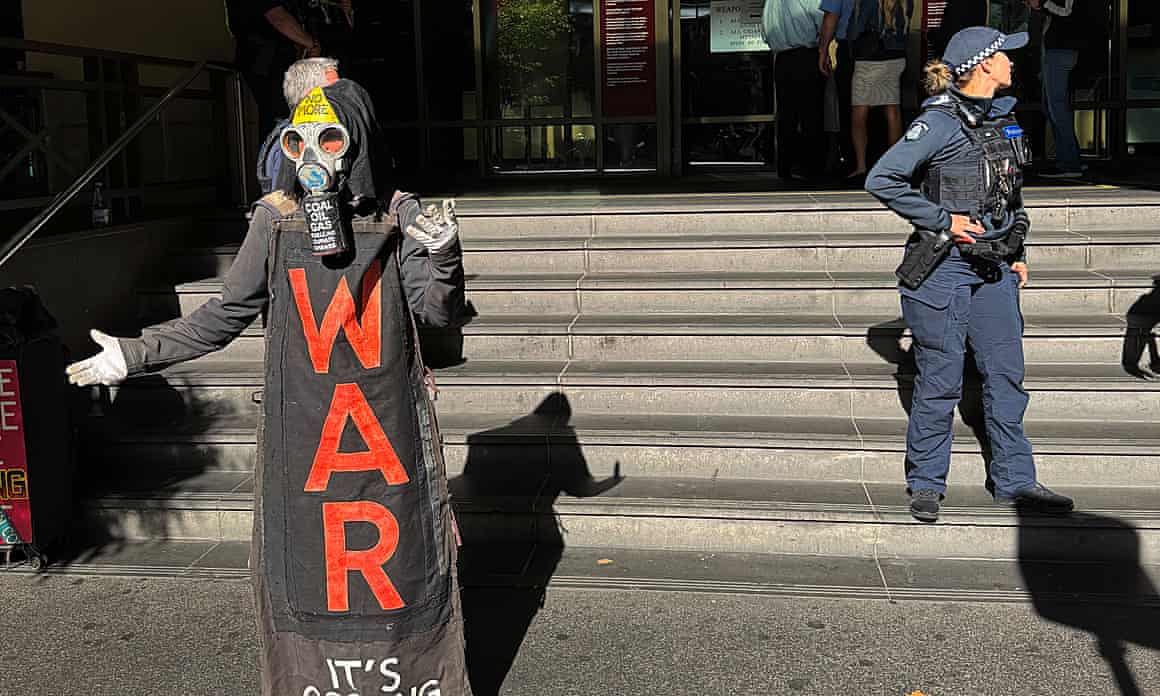 A protester in costume stands outside court steps