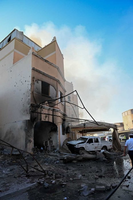 A heavily damaged building and vehicle.