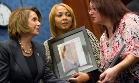 House minority leader Nancy Pelosi comforts Melody McFadden and Stacy Hart, holding a photo of her brother Timmy, who was shot to death.