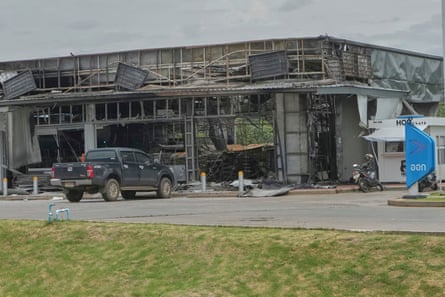 Burnt-out and damaged shell of a convenience store at a petrol station.