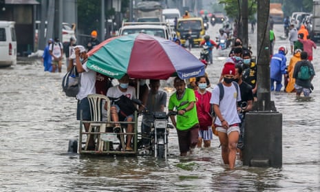 People wade through the flood water brought by heavy monsoon rains in Rizal province east of the Philippine capital Manila. 