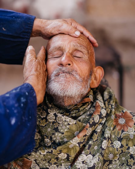 A barber giving face massage at the bazaar, Kashgar