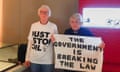 A woman in a Just Stop Oil T-shirt stands alongside another woman holding a sign reading 'The government is breaking the law'
