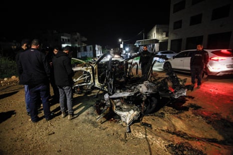 Palestinian men surround a destroyed car after an Israeli airstrike on Jenin in the occupied West Bank last night.