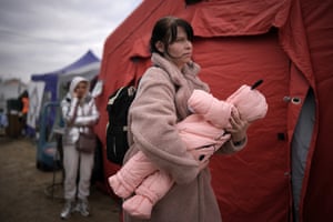 A woman carries her child at the Vysne Nemecke border crossing on 13 March in Vysne Nemecke, Slovakia.