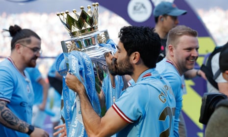 The Manchester City captain, Ilkay Gundogan, kisses the Premier League trophy.