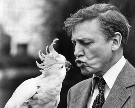 Attenborough holding and lookning at a cockatoo