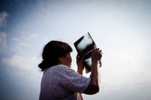 An Indonesian woman observes a solar eclipse through a used x-ray film in Padang, West Sumatra.