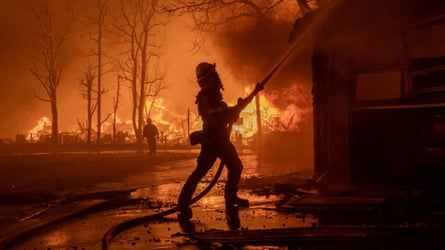 Firefighters silhouetted against flames