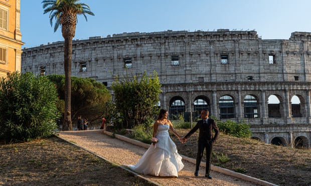 A newlywed couple in front of the Colosseum in Rome.