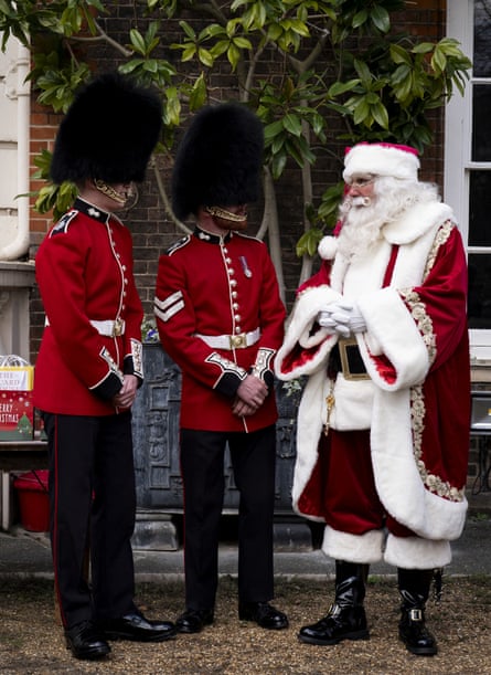 A person dressed as Father Christmas with two members of the Coldstream guards