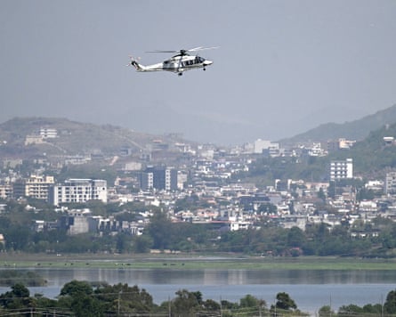 A helicopter flies over Islamabad amid heightened security measures ahead of anticipated US-Iran peace talks.