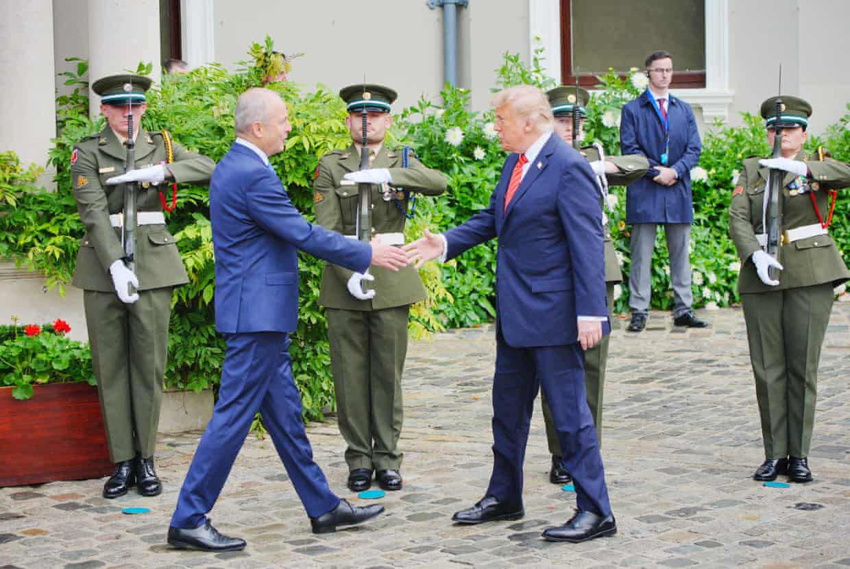 Micheál Martin reaches to shake Donald Trump’s hand in front of soldiers standing at attention