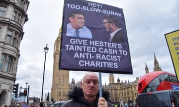 A protester in Parliament Square holds a placard referencing the row about Hester’s remarks and his donation to the Tory party.