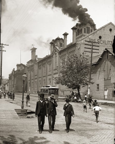 Exterior of Schlitz Brewing Company with two men and a boy in suits and hats in the foreground, Milwaukee, Wisconsin, 1888.