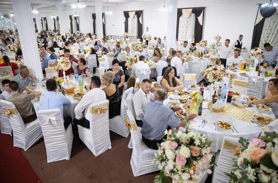 Guests have dinner in the village wedding hall in Cămărzana during the wedding celebration of Jesica Monica Bura and Grigore Pop-Hotcas.  About 1,000 guests attended the party