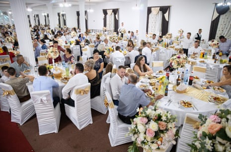Guests eat dinner during the wedding party of Jesica Monica Bura and Grigore Pop-Hotcas in the village wedding hall in Cămărzana. About 1,000 guests attended the party