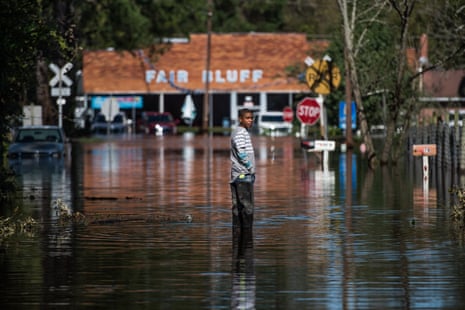 Austin Snowten stands in a flooded street caused by remnants of Hurricane Matthew on October 11, 2016 in Fair Bluff, North Carolina. 