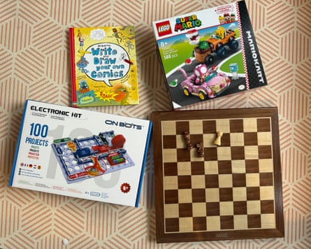 Four boxed children’s gifts, including Lego Mario Kart and a chess set, laid out together
