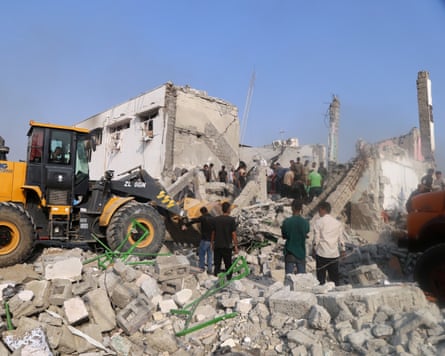 People searching through rubble of a school in Iran.