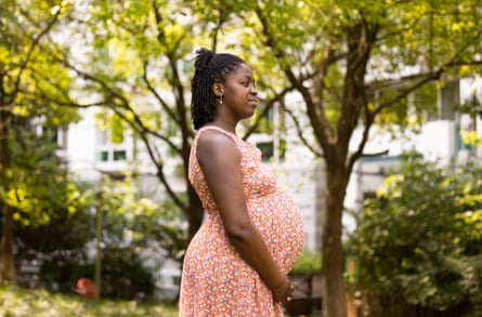Olivia Mendy in a garden while heavily pregnant