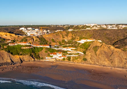 Late afternoon view of sandy beach and cliffs with white buildings