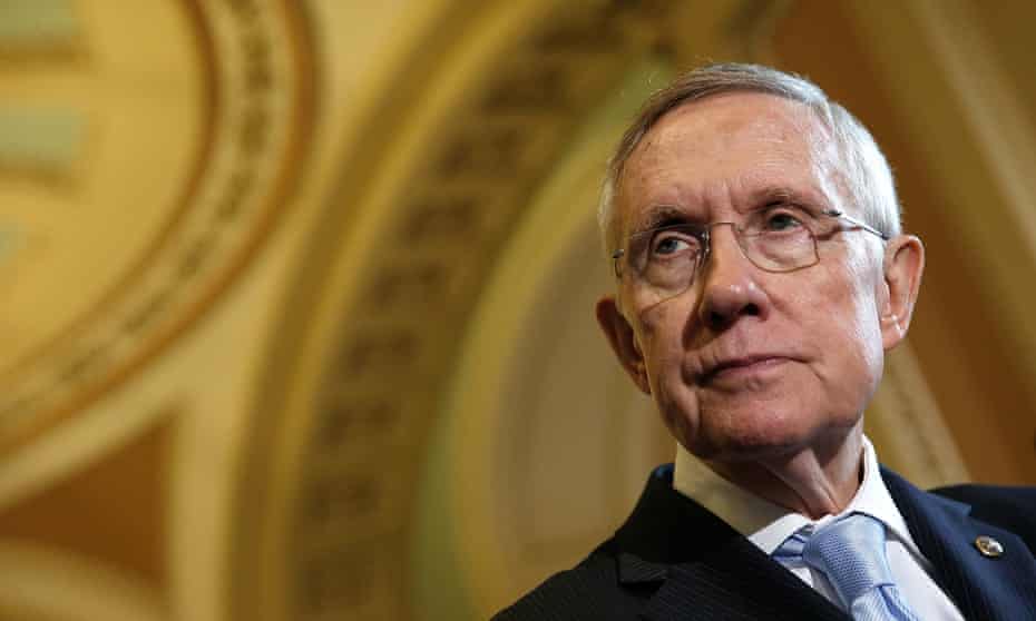 Head and shoulders shot of Harry Reid  in the right of the frame, shot from below so that the ornate ceiling ofd the Capitol Building forms a background